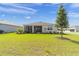 Spacious backyard showcasing a pristine lawn, mature landscaping, and a screened-in lanai at 7706 Sw 89Th Ct, Ocala, FL 34481