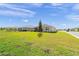 Expansive backyard with manicured lawn, showcasing the home's rear elevation and screened patio at 7706 Sw 89Th Ct, Ocala, FL 34481
