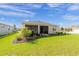Well-maintained backyard featuring a lush lawn, beautiful landscaping, and a covered patio at 7706 Sw 89Th Ct, Ocala, FL 34481