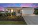 Lovely home featuring a well-manicured lawn, beautiful landscaping, and an attached two-car garage, set against a dramatic sky at 7706 Sw 89Th Ct, Ocala, FL 34481