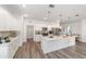 Spacious white kitchen with stainless appliances, a large island, pendant lighting, and modern finishes at 7706 Sw 89Th Ct, Ocala, FL 34481
