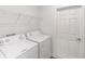 Functional laundry room with appliances and wire shelving at 7706 Sw 89Th Ct, Ocala, FL 34481