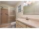 A well-lit bathroom with a glass door shower, and a framed mirror over the vanity at 8654 Sw 96Th St # D, Ocala, FL 34481