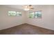 Bedroom features neutral walls, tile flooring, and natural light from the two windows at 8654 Sw 96Th St # D, Ocala, FL 34481