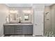 Bathroom featuring double vanity with granite countertop, framed mirrors, and tiled walk-in shower at 8998 Sw 75Th Loop, Ocala, FL 34481