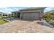 Charming home with a paved driveway leading to a two-car garage, complemented by colorful landscaping at 8998 Sw 75Th Loop, Ocala, FL 34481
