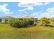Landscaped front yard with lush bushes, green grass, and a quaint exterior at 8998 Sw 75Th Loop, Ocala, FL 34481