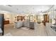 Open concept kitchen with large island, granite counters, stainless appliances, and wood-look floors at 8998 Sw 75Th Loop, Ocala, FL 34481