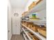 Walk-in pantry with ample shelving for storage, featuring wire racks and a door for access at 8998 Sw 75Th Loop, Ocala, FL 34481