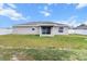 Exterior of the home with view of the yard and patio with sliding glass doors at 9 Walnut Run, Ocala, FL 34480