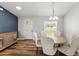 Dining area with a modern sideboard, round table with chairs, and a large window for natural light at 9 Walnut Run, Ocala, FL 34480