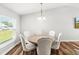 Bright dining room featuring modern light fixture, wood flooring, and a round table with six chairs at 9 Walnut Run, Ocala, FL 34480