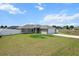 Inviting single-story home with a two-car garage, complemented by a lush green lawn and serene neighborhood at 9 Walnut Run, Ocala, FL 34480