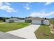 Quaint neighborhood home featuring a two-car garage and neatly-kept front lawn with a white picket fence at 9 Walnut Run, Ocala, FL 34480