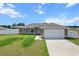 Charming single-story home featuring a two-car garage, well-manicured lawn, and a classic architectural design at 9 Walnut Run, Ocala, FL 34480