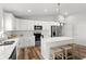 Bright white kitchen boasts stainless steel appliances, pendant lighting, and center island with bar stool seating at 9 Walnut Run, Ocala, FL 34480