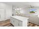 Open floor plan showcases a kitchen island with white cabinets and quartz countertops, seamlessly connecting to the living area at 9 Walnut Run, Ocala, FL 34480