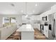 Modern kitchen features white cabinets, stainless steel appliances, island with seating, and flows into the living area at 9 Walnut Run, Ocala, FL 34480