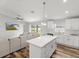Open floor plan showcasing the kitchen island, seamlessly connecting to the living area with a TV at 9 Walnut Run, Ocala, FL 34480