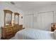 Inviting bedroom with vintage dresser, closet, and natural light, offering comfort and functionality at 9565 Sw 194Th Cir, Dunnellon, FL 34432