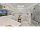 Open kitchen with ample counter space, white cabinetry, modern appliances, and a breakfast bar at 9565 Sw 194Th Cir, Dunnellon, FL 34432