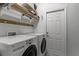 Functional laundry room with washer, dryer, and storage shelves, maximizing space and organization at 9565 Sw 194Th Cir, Dunnellon, FL 34432
