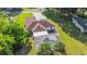 An aerial view showcases a home with a screened pool, a carport, and a detached garage amid a lush green landscape at 10140 Sw 81St Terrace Rd, Ocala, FL 34481