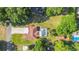 An aerial view showcasing a home with a screened pool, a carport, and a detached garage amid a lush green landscape at 10140 Sw 81St Terrace Rd, Ocala, FL 34481