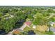 Aerial view of a home with screened pool, detached garage, surrounded by trees and greenery in a residential area at 10140 Sw 81St Terrace Rd, Ocala, FL 34481