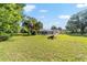 Expansive backyard with lush lawn, mature trees, and a screened-in pool area, ideal for outdoor enjoyment at 10140 Sw 81St Terrace Rd, Ocala, FL 34481