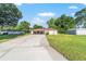 Charming single-story home with a long driveway, covered carport and manicured lawn at 10140 Sw 81St Terrace Rd, Ocala, FL 34481