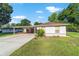 Charming single-story home with a covered carport, lovely landscaping and a paved driveway at 10140 Sw 81St Terrace Rd, Ocala, FL 34481