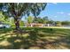 Sprawling front yard with mature trees and a covered carport, perfect for outdoor activities at 10140 Sw 81St Terrace Rd, Ocala, FL 34481