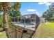 Beautiful backyard with a screened-in pool and spacious patio area surrounded by lush landscaping at 10140 Sw 81St Terrace Rd, Ocala, FL 34481