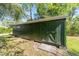 Exterior shot of the green shed with double doors and a small window, providing outdoor storage space at 10140 Sw 81St Terrace Rd, Ocala, FL 34481