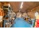 Insulated workshop interior with blue flooring, featuring workbenches, shelving, and ample workspace at 10140 Sw 81St Terrace Rd, Ocala, FL 34481