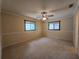 Carpeted bedroom with ceiling fan and two windows at 10330 Sw 99Th Ave, Ocala, FL 34481