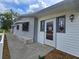 Front entrance, with side trim windows, storm door, sidewalk and stone base at 10330 Sw 99Th Ave, Ocala, FL 34481