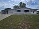 Charming single-story home with a carport, gray exterior, and a well-maintained front yard at 10330 Sw 99Th Ave, Ocala, FL 34481