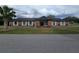 Single story brick building with blue trim, mature landscaping and a sidewalk leading to a front entrance at 10330 Sw 99Th Ave, Ocala, FL 34481