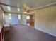 Spacious living room with carpet, a ceiling fan, and transition to wood flooring at 10330 Sw 99Th Ave, Ocala, FL 34481