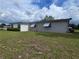 The rear view of a single story gray house with well kept green grass and minimal shrubbery at 10330 Sw 99Th Ave, Ocala, FL 34481