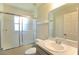 Bright bathroom showcasing a vanity sink and a shower-tub combination with glass doors at 11609 Sw 59Th Ter, Ocala, FL 34476