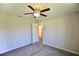 Neutral carpeted bedroom with open door looking into the hallway and overhead ceiling fan at 11609 Sw 59Th Ter, Ocala, FL 34476