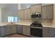 Modern kitchen featuring stainless steel appliances, gray cabinets, and quartz countertops at 11609 Sw 59Th Ter, Ocala, FL 34476