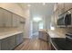 Modern kitchen with stainless steel appliances, gray cabinets, and quartz countertops at 11609 Sw 59Th Ter, Ocala, FL 34476