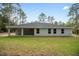 Backyard view of the home showcasing the back porch and large lot at 12953 Sw 85Th Pl, Dunnellon, FL 34432