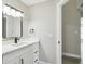 Bathroom featuring a white vanity with black fixtures, mirror, modern lighting, and white walls at 1317 Ravida Woods Dr, Apopka, FL 32703
