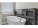 Modern bathroom showcasing a freestanding tub against the elegant black marble at 1317 Ravida Woods Dr, Apopka, FL 32703