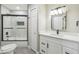 Stylish bathroom features a white vanity, tub and shower combo with glass doors, and modern fixtures at 1317 Ravida Woods Dr, Apopka, FL 32703